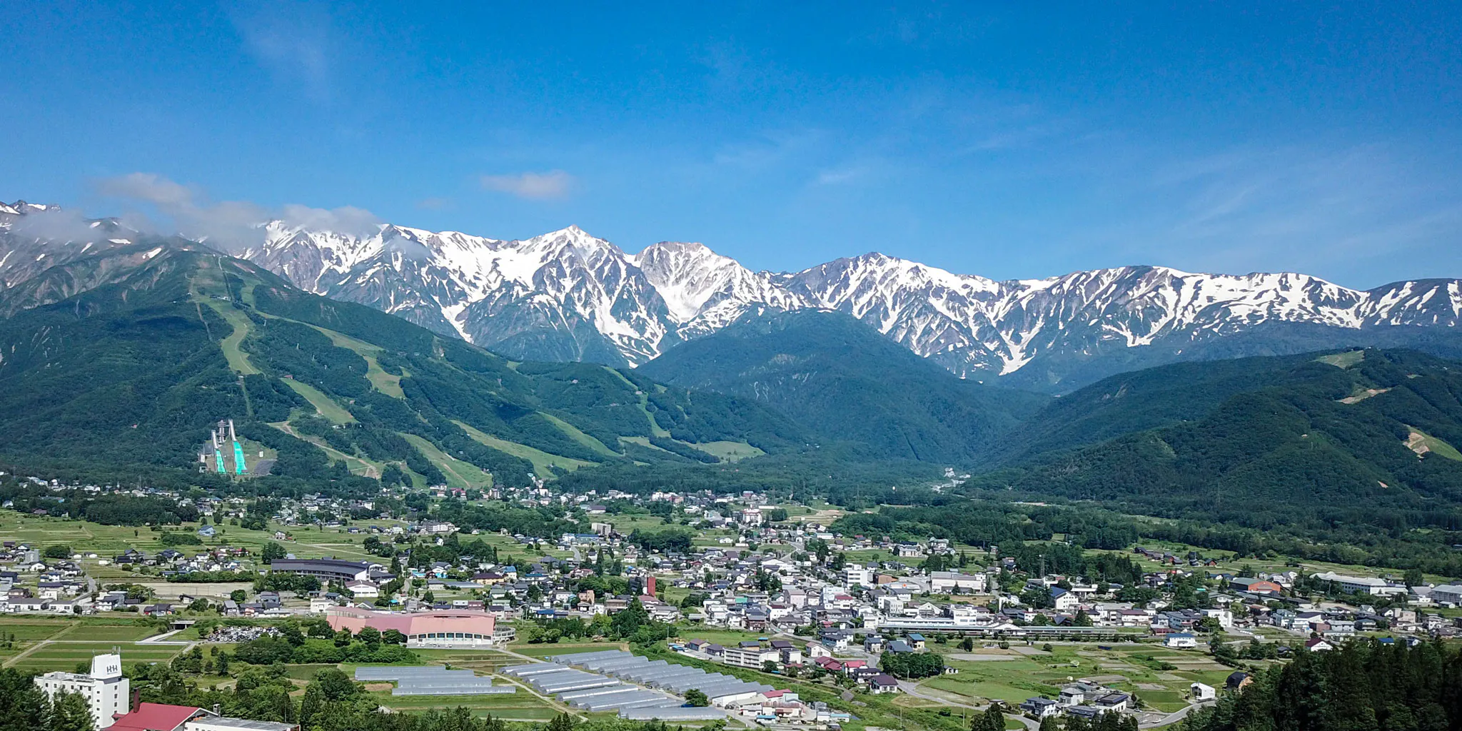 Aerial view of Hakuba village and ski jump stadium beneath the Hakuba mountain range