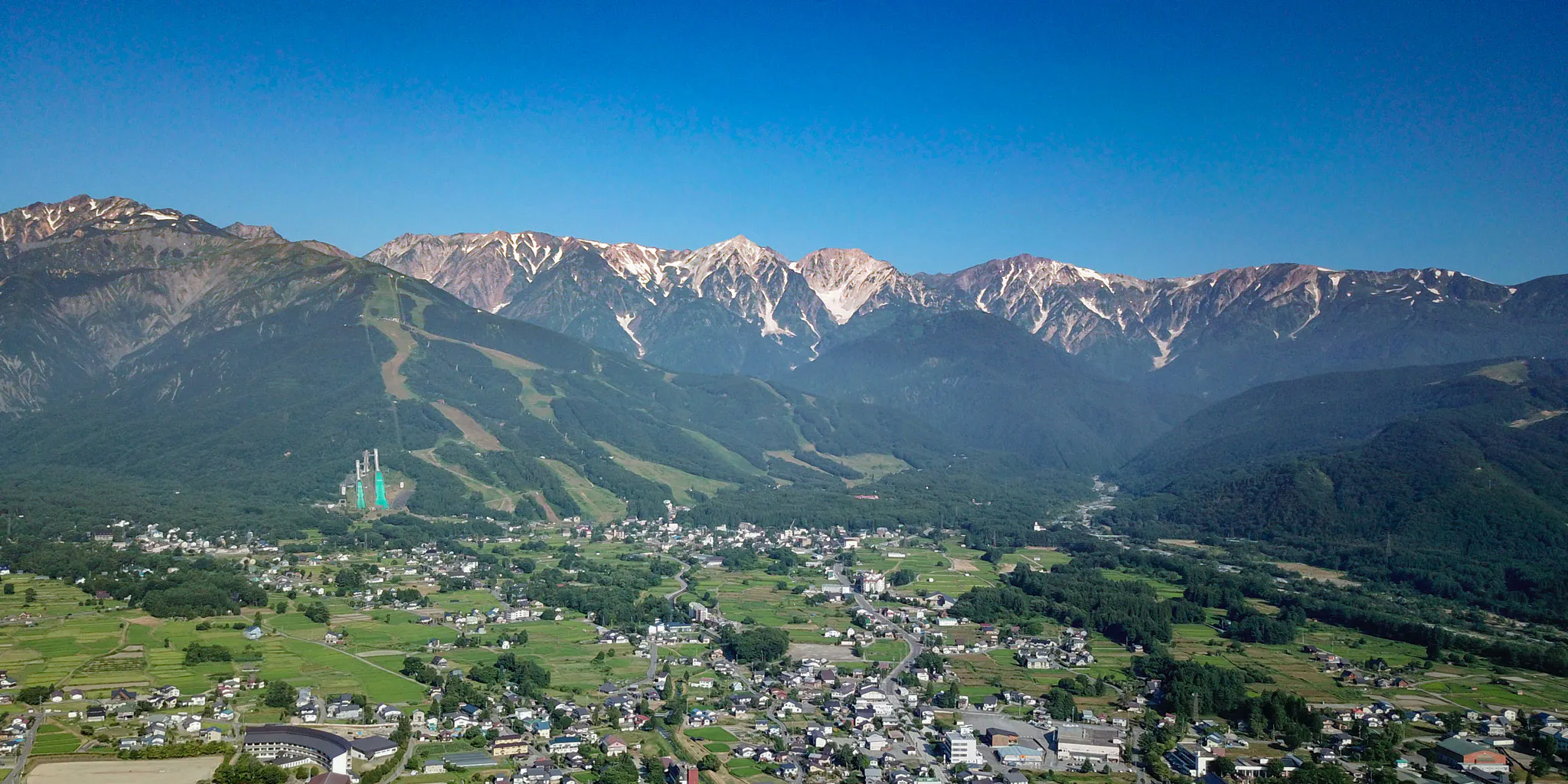 Morning aerial view of Hakuba village and its rice fields beneath the Hakuba Sanzan range