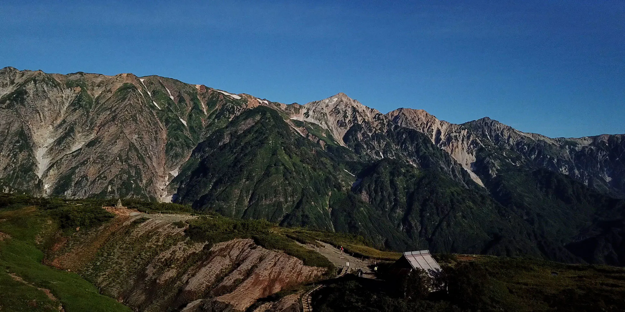 View of a mountain hut standing on a rocky ridge along the hiking trail