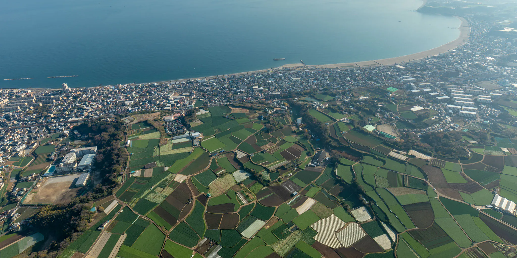 Aerial view of farmland resembling cabbage fields on the Miura Peninsula alongside a coastal town