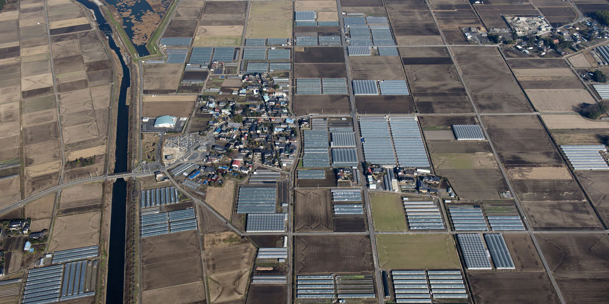 Aerial view of farmland and a rural village along a waterway