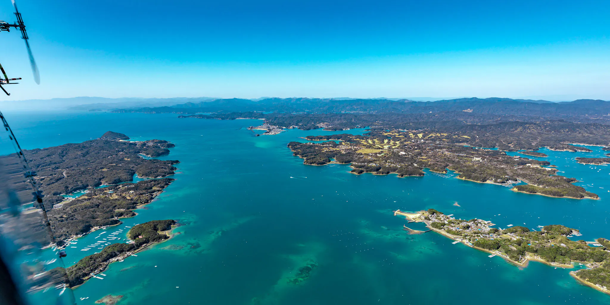 View of the ria coastline and islands with the helicopter rotor in frame