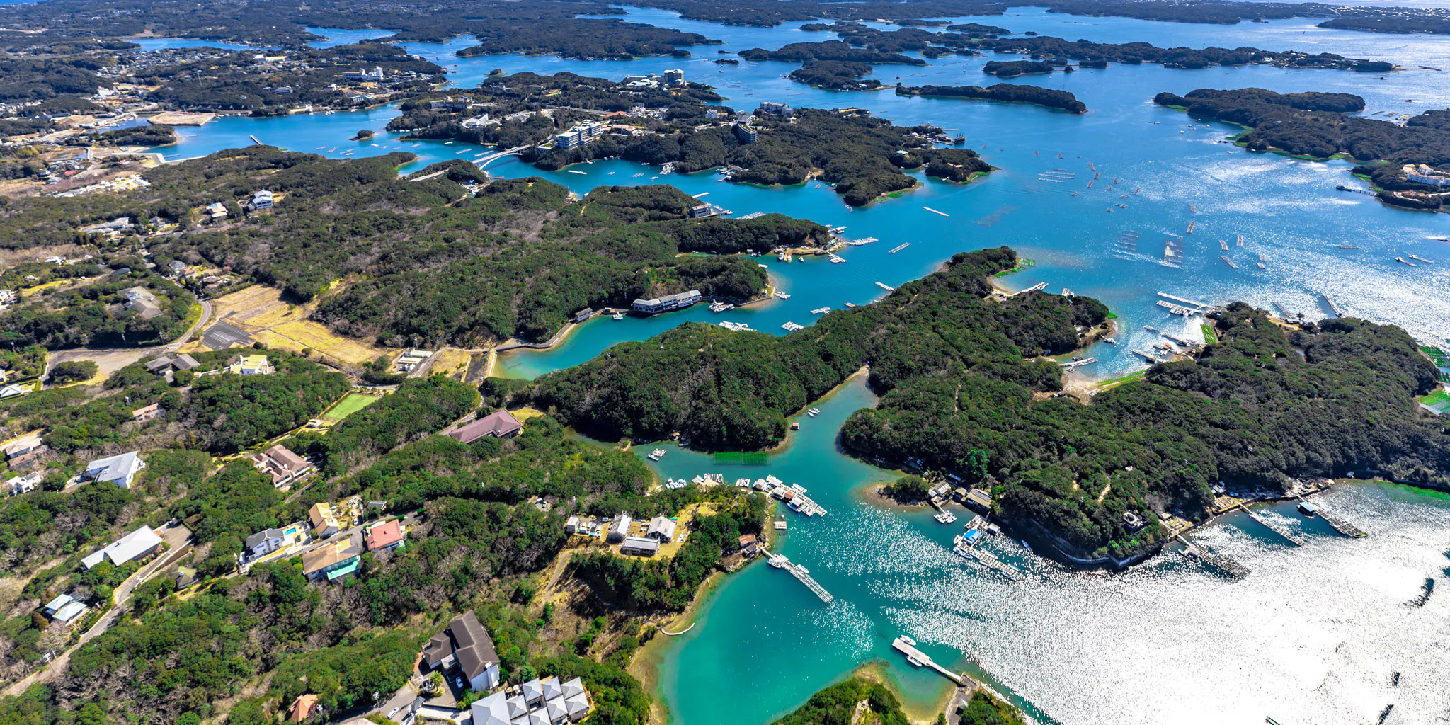 Aerial view of a coastal village with marinas lining a winding waterway