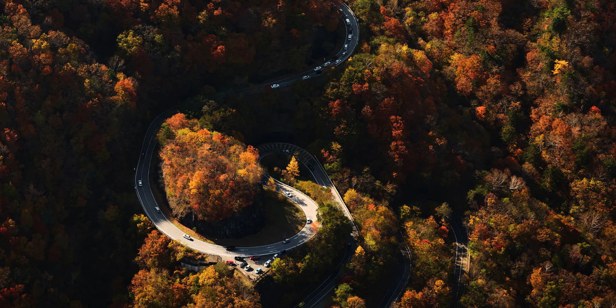Aerial view of the hairpin curves of Nikko's Irohazaka road amid autumn colors